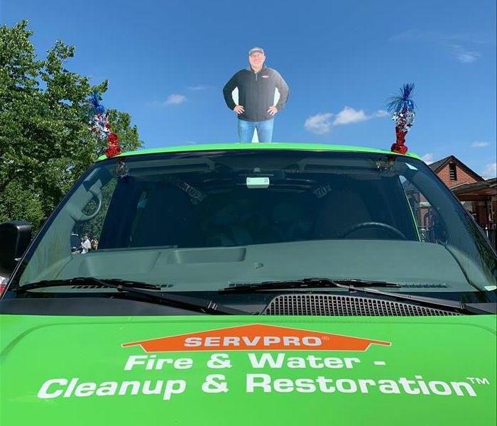 SERVPRO van with flat cutout of our owner standing on the roof